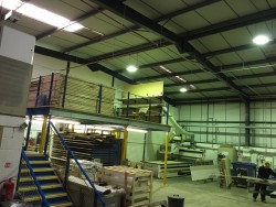 View of workshop showing CNC machine, mezzanine storage level and ground level laminate storage