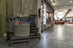Wood effect laminated housing to retail section with crate and basket style bric a brac to house crisps and other impulse items