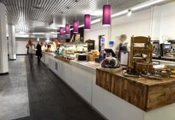 Bespoke servery counters with Corian worktops, gloss laminate front panels, walnut capping corner sections with feature lighting and stone effect vinyl flooring