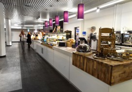 Bespoke servery counters with Corian worktops, gloss laminate front panels, walnut capping corner sections with feature lighting and stone effect vinyl flooring