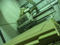 CNC routing machine with routered boards on bed
