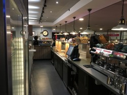 Backbar view of counter showing open ambient shelving below corian worktop