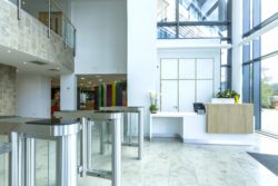 Concirege Desk and wall panelling, desk finsihed in White Corian with brushed effect stainless steel laminate kikc plinths and woodgrain feature boxes, wall paneeling behind to match finishes and hide access door